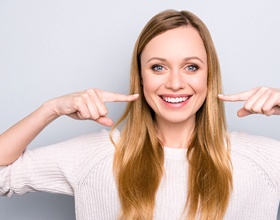 Woman showing off smile after dental bridge restoration