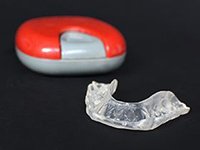 protective mouthguard next to its storage case