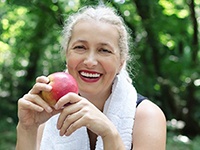 woman eating a red apple after exercising