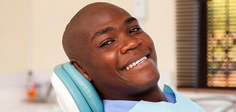 Smiling man in dental chair after gum disease therapy