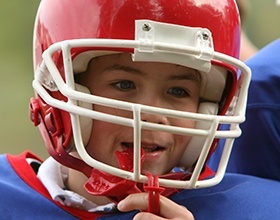 Young boy placing sports mouthguard