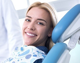 Smiling woman in dental chair after T M J therapy