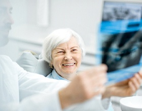 Happy senior female patient at appointment with dentist
