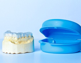 nightguard on dental model next to blue case