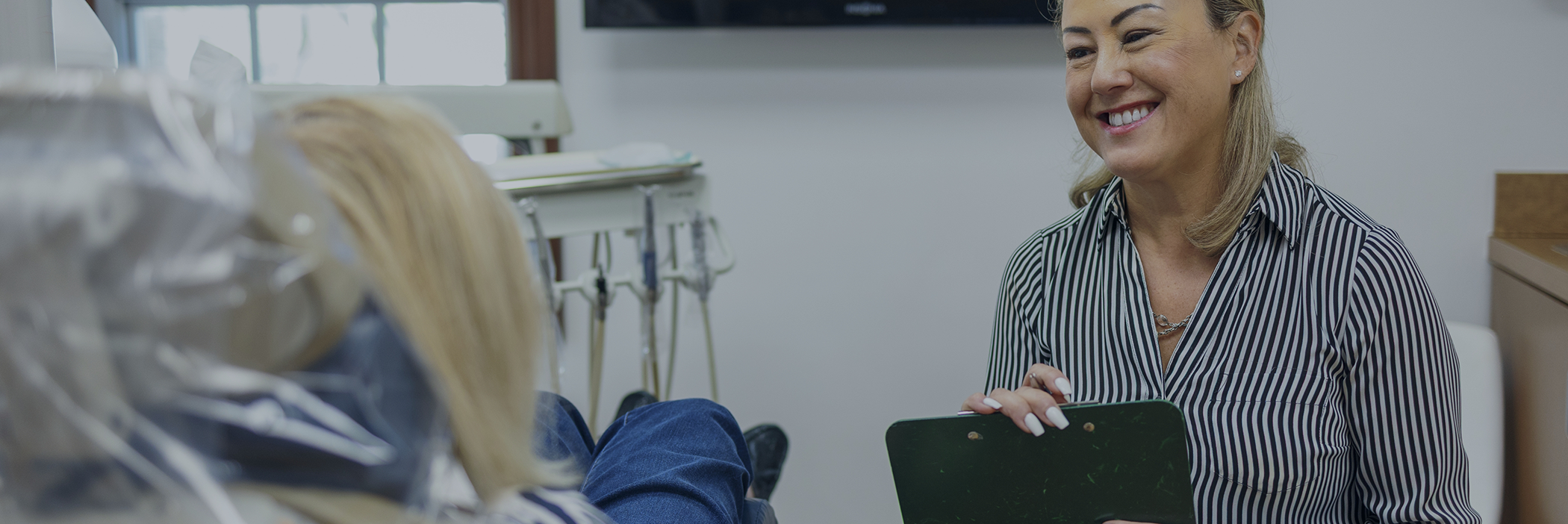 Dental team member listening to a patient at a cosmetic dentistry consultation