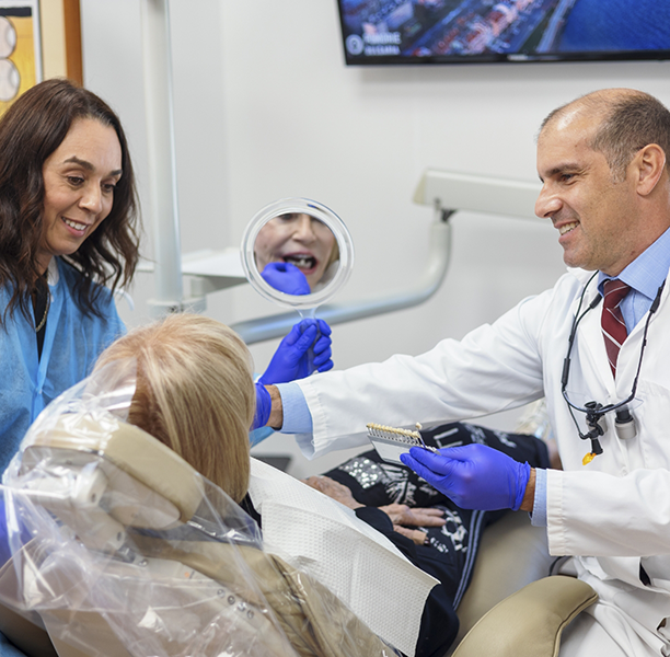Doctor Lamberti showing a patient a shade guide for veneers