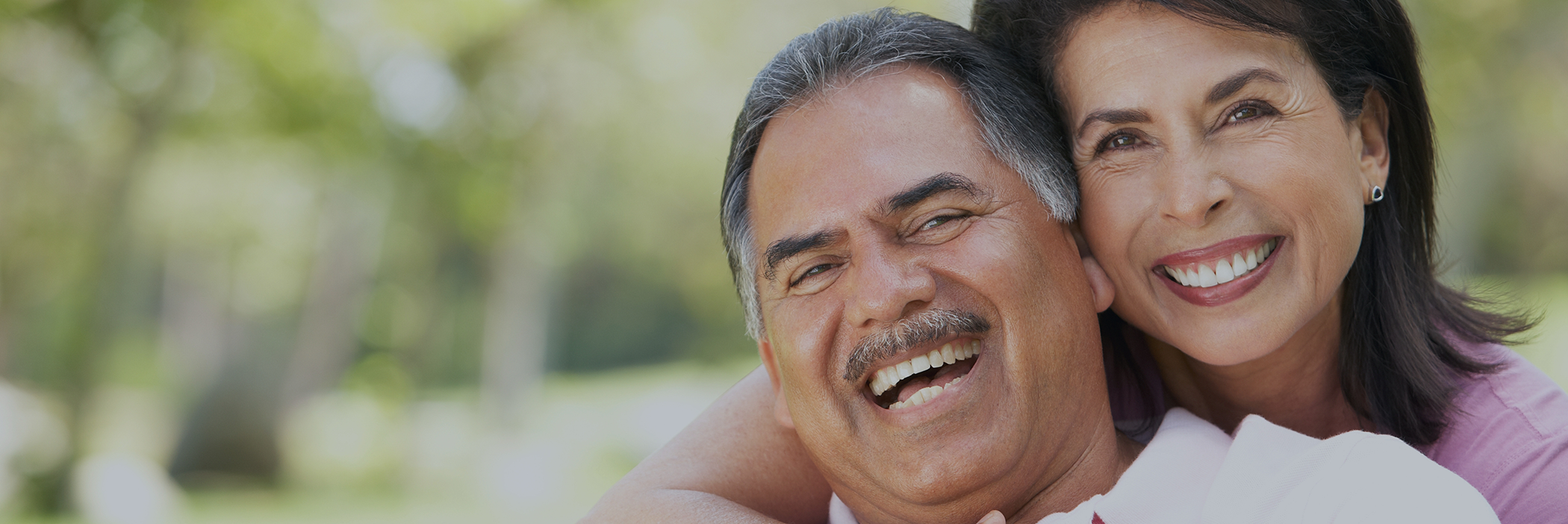 Older couple smiling outdoors with dental implant dentures in Boca Raton