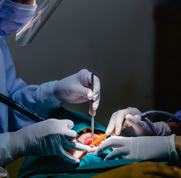 Dental team performing dental implant surgery on a patient