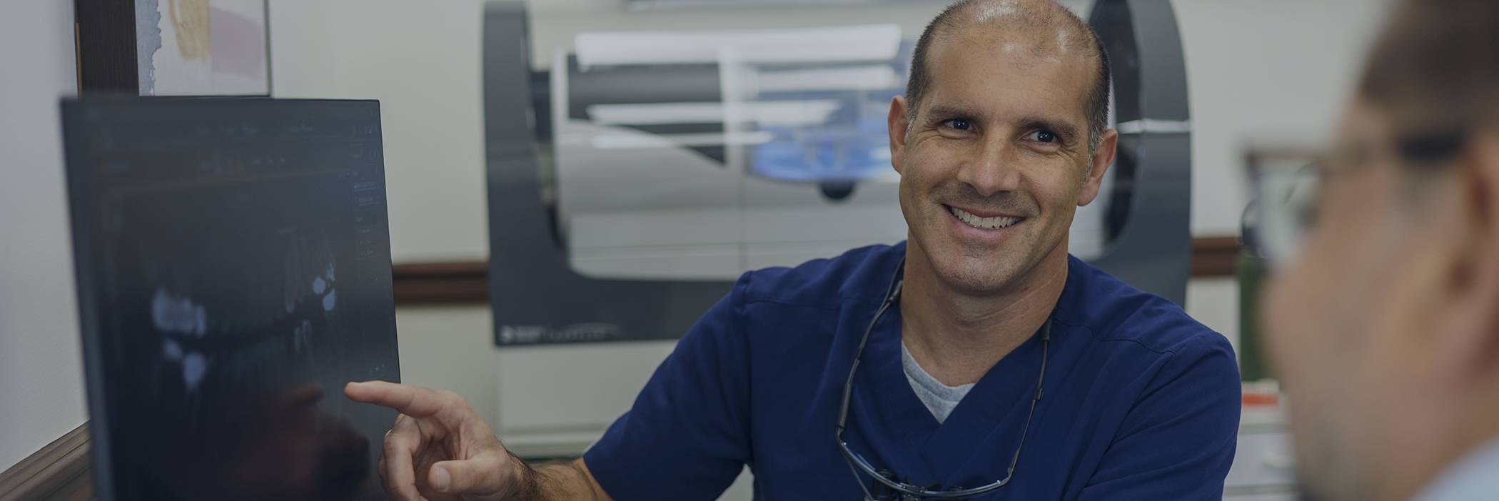 Doctor Alberto Lamberti smiling at a patient with dental implants in Boca Raton