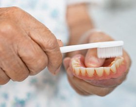 Close up of man brushing his denture