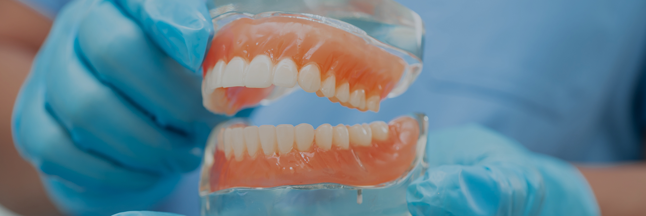 Dentist holding a model of dentures in Boca Raton