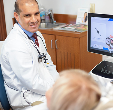 Doctor Lamberti smiling at a patient in the dental chair
