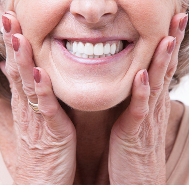 Smiling senior woman touching her face