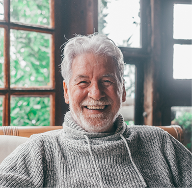Smiling senior man in a gray sweater