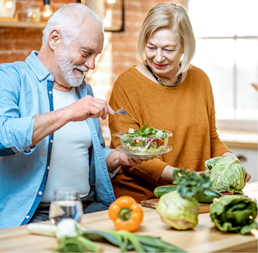 Older couple making salads in their kitchen