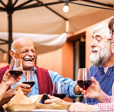 Group of adults having red wine together