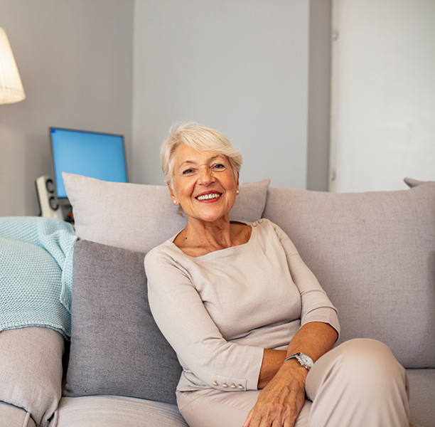 Smiling older woman sitting on her couch