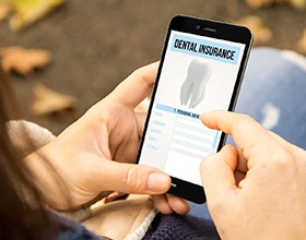 Woman looking at dental insurance form on her phone