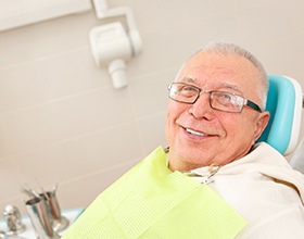 Older man with dentures in Boca Raton, FL sitting in dental chair