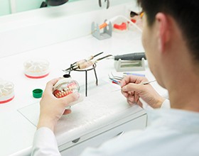 Lab tech in white building dentures