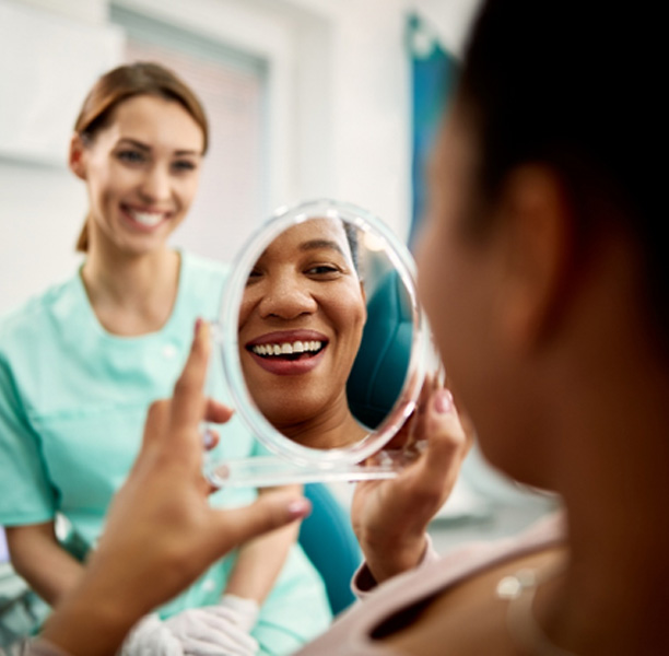 Patient smiling at reflection in treatment chair