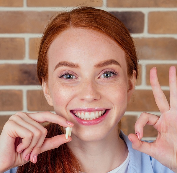 A woman holding a tooth
