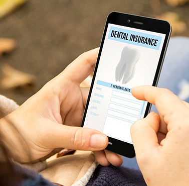 A woman verifying dental insurance coverage on her phone