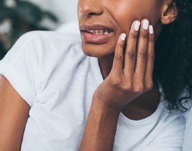 Closeup of pained woman in need of dental implant salvage in Boca Raton