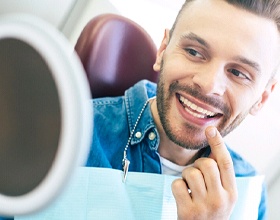Man admiring his smile after dental implant salvage in Boca Raton