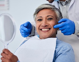 Patient smiling as dentist points to her teeth