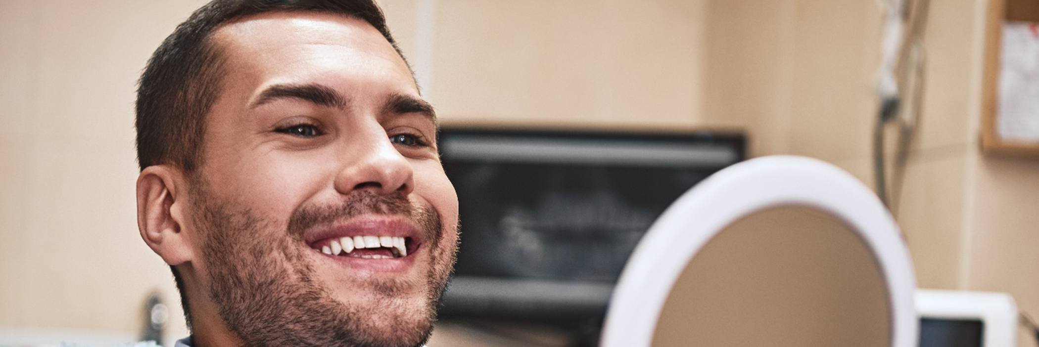 Man smiling with handheld mirror