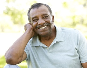 Man with dental implant supported dentures in Boca Raton smiling outside