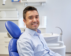 Man smiling while sitting in treatment chair