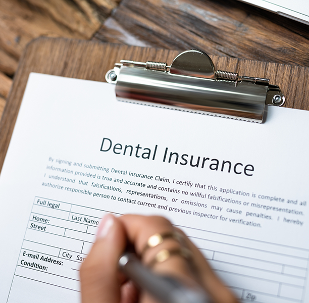 Person filling out a dental insurance form