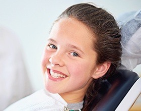 Smiling child in dental chair after fluoride treatment