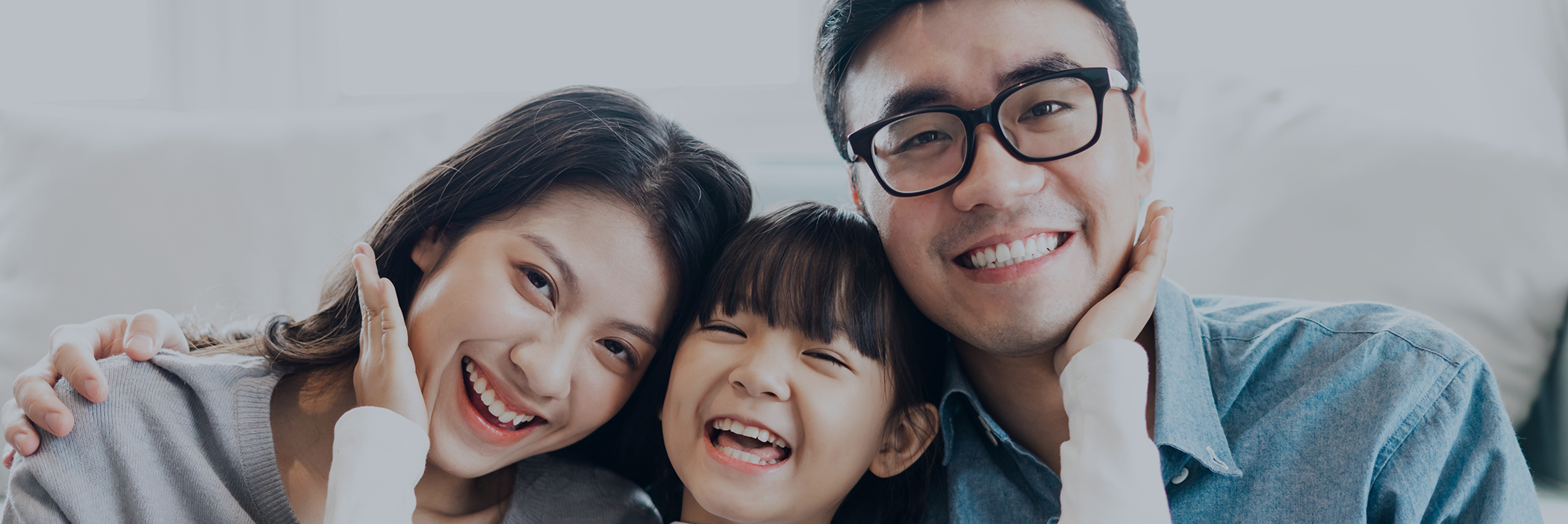 Family of three smiling after a preventive dentistry checkup