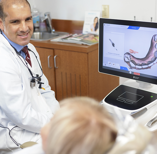 Doctor Lamberti talking with a patient in the exam chair