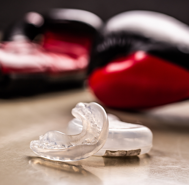 Clear mouthguard next to two boxing gloves