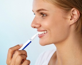 Woman using teeth whitening pen
