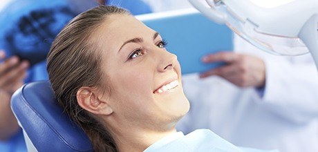 Woman smiling while receiving treatment with advanced dental services and techology