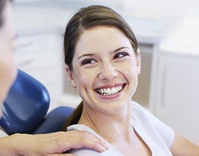Smiling woman in dental chair enjoying patient amenities