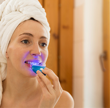 Woman using a take-home teeth whitening kit