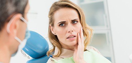 Woman holding jaw in pain before T M J therapy