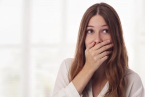 embarrassed woman hiding mouth