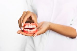 Closeup of dentist holding full set of dentures