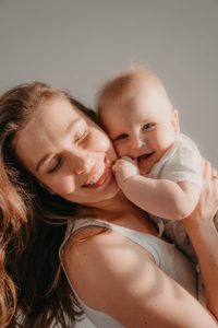 Smiling woman holding a baby