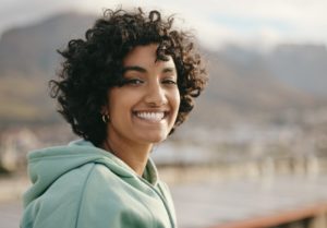 a woman smiling with healthy teeth and mental health 